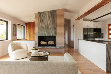 Example of a mid-sized 1950s open concept light wood floor and vaulted ceiling living room design in Seattle with a standard fireplace and a brick fireplace