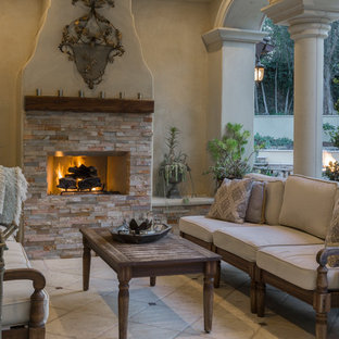 Mediterraner Patio hinter dem Haus mit Outdoor-Küche, Granitsplitt und Markisen in Los Angeles