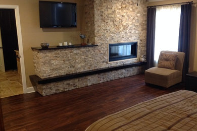 Inspiration for a large contemporary master dark wood floor bedroom remodel in Nashville with beige walls, a standard fireplace and a stone fireplace