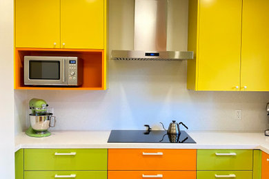 Mid-sized eclectic l-shaped light wood floor enclosed kitchen photo in Toronto with a double-bowl sink, flat-panel cabinets, yellow cabinets, quartz countertops, white backsplash, quartz backsplash, stainless steel appliances, no island and white countertops