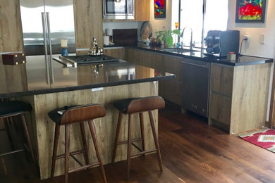 Inspiration for a mid-sized modern l-shaped medium tone wood floor and brown floor eat-in kitchen remodel in Other with a single-bowl sink, flat-panel cabinets, distressed cabinets, quartz countertops, stainless steel appliances, an island and brown countertops