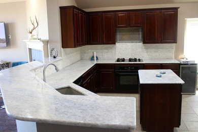 Kitchen - mid-sized modern ceramic tile kitchen idea in Austin with a single-bowl sink, quartzite countertops, white backsplash, stone tile backsplash, black appliances, an island, raised-panel cabinets and dark wood cabinets