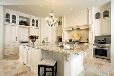 Foto di una grande cucina chic chiusa con ante bianche, top in granito, paraspruzzi beige, elettrodomestici in acciaio inossidabile e pavimento beige