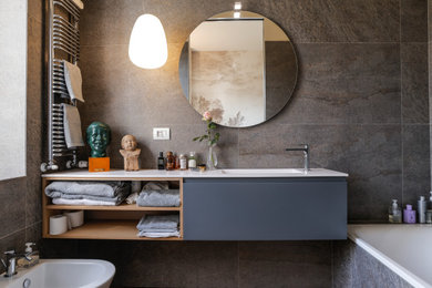 Diseño de cuarto de baño contemporáneo con bañera encastrada, sanitario de pared, baldosas y/o azulejos de porcelana y suelo de madera clara