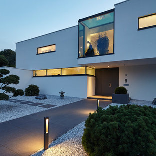 ケルンの中サイズの回転式ドアモダンスタイルのおしゃれな玄関ドア (白い壁、コンクリートの床、黒いドア、グレーの床) の写真