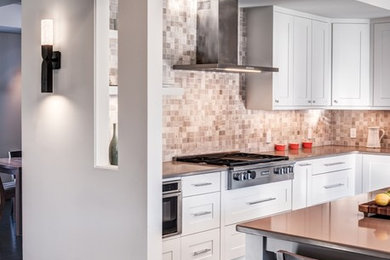Open concept kitchen - transitional l-shaped dark wood floor open concept kitchen idea in DC Metro with an undermount sink, recessed-panel cabinets, white cabinets, quartz countertops, brown backsplash, stone tile backsplash, stainless steel appliances and an island
