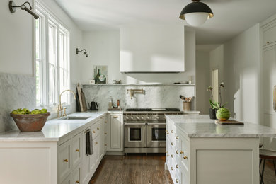 Kitchen - mid-sized traditional medium tone wood floor and brown floor kitchen idea in Boston with an undermount sink, shaker cabinets, white cabinets, marble countertops, white backsplash, marble backsplash, stainless steel appliances, an island and white countertops