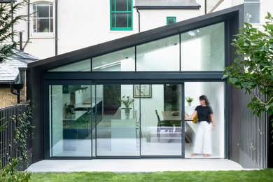 Design ideas for a medium sized modern single-wall kitchen/diner in London with flat-panel cabinets, blue cabinets, engineered stone countertops, stainless steel appliances, an island and grey worktops.