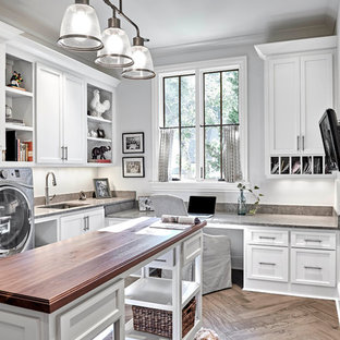 Ejemplo de lavadero multiusos, tradicional renovado, de tamaño medio, con fregadero bajoencimera, puertas de armario blancas, paredes blancas, suelo de madera clara, armarios abiertos, encimera de piedra caliza, lavadora y secadora juntas, suelo marrón y encimeras marrones