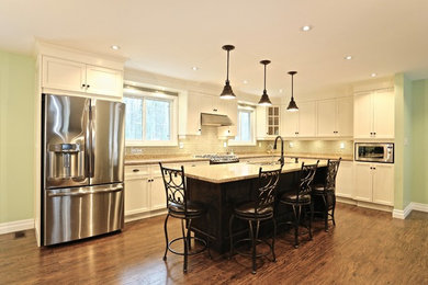 Open concept kitchen - large l-shaped medium tone wood floor open concept kitchen idea in Toronto with a double-bowl sink, recessed-panel cabinets, white cabinets, quartz countertops, stainless steel appliances and an island