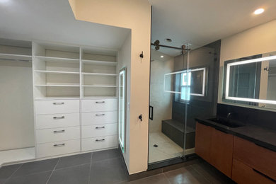 Example of a mid-sized trendy master beige tile and porcelain tile porcelain tile, gray floor and double-sink bathroom design in Miami with flat-panel cabinets, medium tone wood cabinets, a one-piece toilet, white walls, an undermount sink, quartz countertops, black countertops and a floating vanity