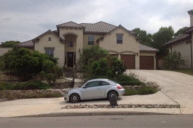 Mid-sized transitional beige split-level stone exterior home photo in Austin with a hip roof