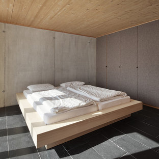 Modernes Schlafzimmer mit grauer Wandfarbe und Schieferboden in Sonstige