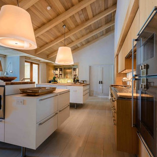 Mid-sized contemporary kitchen pantry designs - Mid-sized trendy galley medium tone wood floor kitchen pantry photo in DC Metro with a drop-in sink, flat-panel cabinets, medium tone wood cabinets, wood countertops, stainless steel appliances and two islands