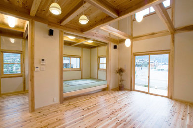 Asian open concept living room with white walls, medium hardwood floors and beige floor.