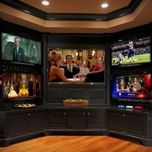 Photo of a medium sized traditional enclosed home cinema in Louisville with beige walls, medium hardwood flooring, a built-in media unit and brown floors.