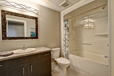 Mid-sized trendy master beige floor bathroom photo in Toronto with flat-panel cabinets, dark wood cabinets, a two-piece toilet, beige walls and a drop-in sink