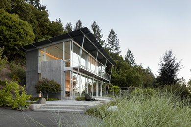 Идея дизайна: двухэтажный, серый частный загородный дом в стиле модернизм с облицовкой из бетона