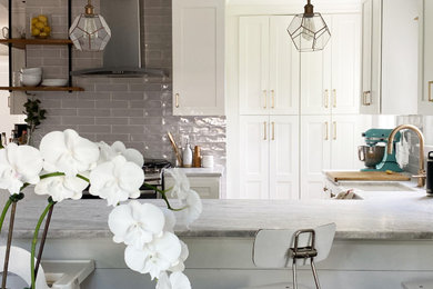 Eat-in kitchen - mid-sized farmhouse u-shaped dark wood floor and brown floor eat-in kitchen idea in New York with a farmhouse sink, shaker cabinets, white cabinets, quartzite countertops, gray backsplash, ceramic backsplash, stainless steel appliances, a peninsula and multicolored countertops