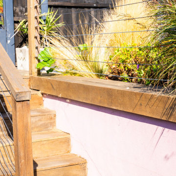 Wire balustrade and wooden stairs in split level garden