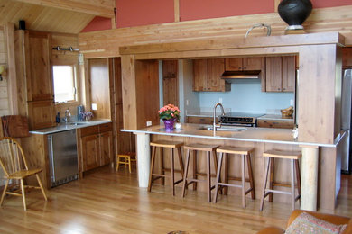 Open concept kitchen - mid-sized contemporary l-shaped light wood floor open concept kitchen idea in Seattle with an undermount sink, shaker cabinets, medium tone wood cabinets, granite countertops, stainless steel appliances and no island