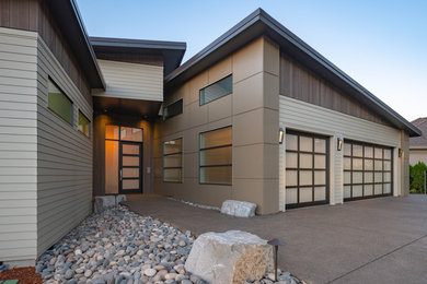 Example of a trendy beige concrete fiberboard house exterior design in Portland with a shed roof and a metal roof