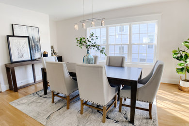 Photo of a mid-sized transitional open plan dining in DC Metro with white walls, medium hardwood floors, no fireplace and brown floor.