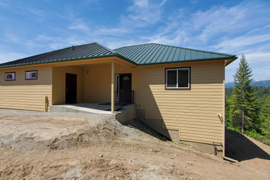Example of a large trendy beige two-story concrete fiberboard and clapboard house exterior design in Seattle with a hip roof and a metal roof