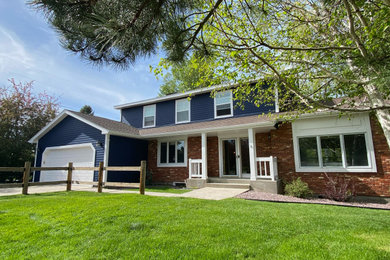 Inspiration for a large farmhouse blue two-story wood and clapboard exterior home remodel in Other with a shingle roof and a brown roof