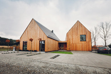 Diseño de fachada de casa marrón y negra moderna grande de dos plantas con revestimiento de madera, tejado a dos aguas, tejado de teja de barro y panel y listón