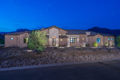 Photo of a large contemporary one-storey stucco multi-coloured house exterior in Phoenix with a tile roof.