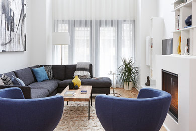 Living room library - mid-sized contemporary open concept light wood floor and beige floor living room library idea in Toronto with white walls, a standard fireplace and no tv