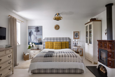 Imagen de dormitorio principal escandinavo pequeño con paredes blancas, suelo de madera pintada, todas las chimeneas, marco de chimenea de baldosas y/o azulejos, suelo blanco, casetón y boiserie
