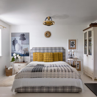 Imagen de dormitorio principal, casetón y boiserie, escandinavo, pequeño, boiserie, con paredes blancas, suelo de madera pintada, todas las chimeneas, marco de chimenea de baldosas y/o azulejos, suelo blanco y boiserie