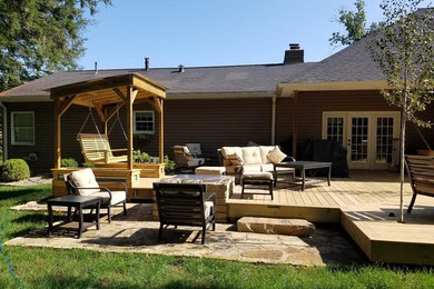 Photo of a large country backyard patio in Huntington with decking, no cover and a fire feature.