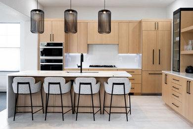 Inspiration for a mid-sized modern l-shaped ceramic tile and gray floor eat-in kitchen remodel in Denver with a drop-in sink, flat-panel cabinets, light wood cabinets, solid surface countertops, gray backsplash, quartz backsplash, paneled appliances, an island and white countertops