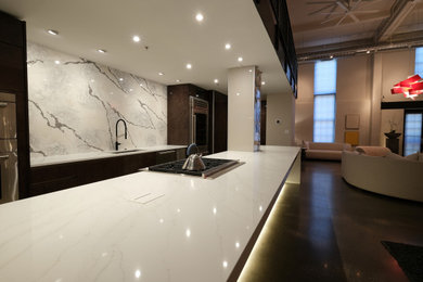 Open concept kitchen - mid-sized modern galley concrete floor and gray floor open concept kitchen idea in Baltimore with an undermount sink, flat-panel cabinets, brown cabinets, quartz countertops, white backsplash, quartz backsplash, stainless steel appliances, no island and white countertops