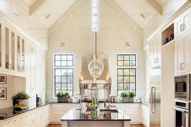 Inspiration for a mid-sized transitional u-shaped eat-in kitchen in Chicago with a double-bowl sink, raised-panel cabinets, white cabinets, marble benchtops, beige splashback, ceramic splashback, stainless steel appliances, dark hardwood floors and no island.