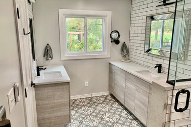 Bathroom - mid-sized farmhouse master white tile and subway tile ceramic tile and multicolored floor bathroom idea in Other with flat-panel cabinets, light wood cabinets, gray walls, an undermount sink, quartz countertops, a hinged shower door and white countertops