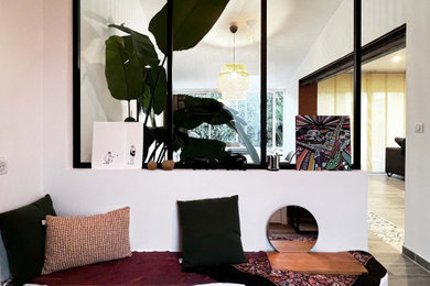 Cette photo montre un grand hall d'entrée éclectique avec un mur orange, un sol en carrelage de céramique, une porte simple, une porte blanche et un sol gris.