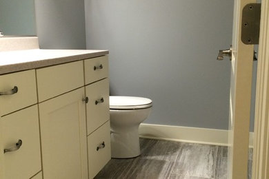 Mid-sized transitional porcelain tile powder room photo in Other with recessed-panel cabinets, beige cabinets, quartz countertops, gray walls and an undermount sink