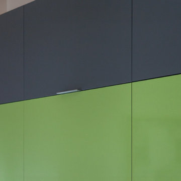Closeup of gray acrylic slab cabinet doors coordinating with Formica Lime green