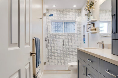 Mid-sized transitional kids' blue tile and glass sheet porcelain tile, gray floor and single-sink alcove shower photo in San Francisco with shaker cabinets, blue cabinets, a one-piece toilet, gray walls, an undermount sink, quartz countertops, a hinged shower door, gray countertops, a niche and a built-in vanity