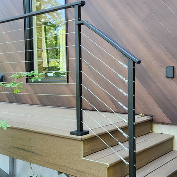 Deck with black metal post cable railing in Quebec, Canada