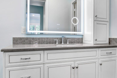 Inspiration for a huge transitional master gray tile and ceramic tile porcelain tile, gray floor and single-sink bathroom remodel in Los Angeles with raised-panel cabinets, an undermount tub, an undermount sink, quartz countertops, a hinged shower door, gray countertops and a built-in vanity