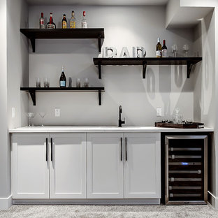 カルガリーのトランジショナルスタイルのおしゃれなウェットバー (アンダーカウンターシンク、シェーカースタイル扉のキャビネット、白いキャビネット、カーペット敷き) の写真