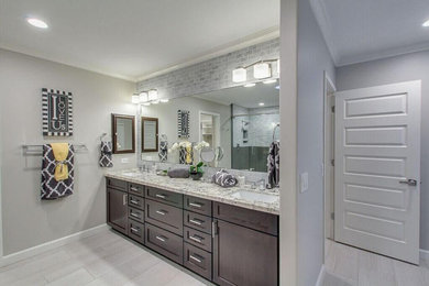 Example of a mid-sized transitional master ceramic tile doorless shower design in Phoenix with flat-panel cabinets, dark wood cabinets, a one-piece toilet, gray walls, a drop-in sink and granite countertops