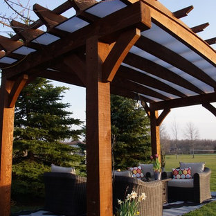 Photo of a mid-sized arts and crafts backyard patio in Toronto with a pergola.