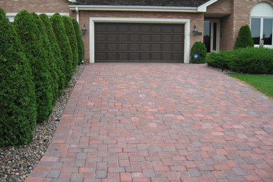 Design ideas for a large traditional front yard full sun driveway in Minneapolis with brick pavers.