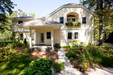 Mid-sized elegant multicolored two-story stucco house exterior photo in Minneapolis with a clipped gable roof and a shingle roof